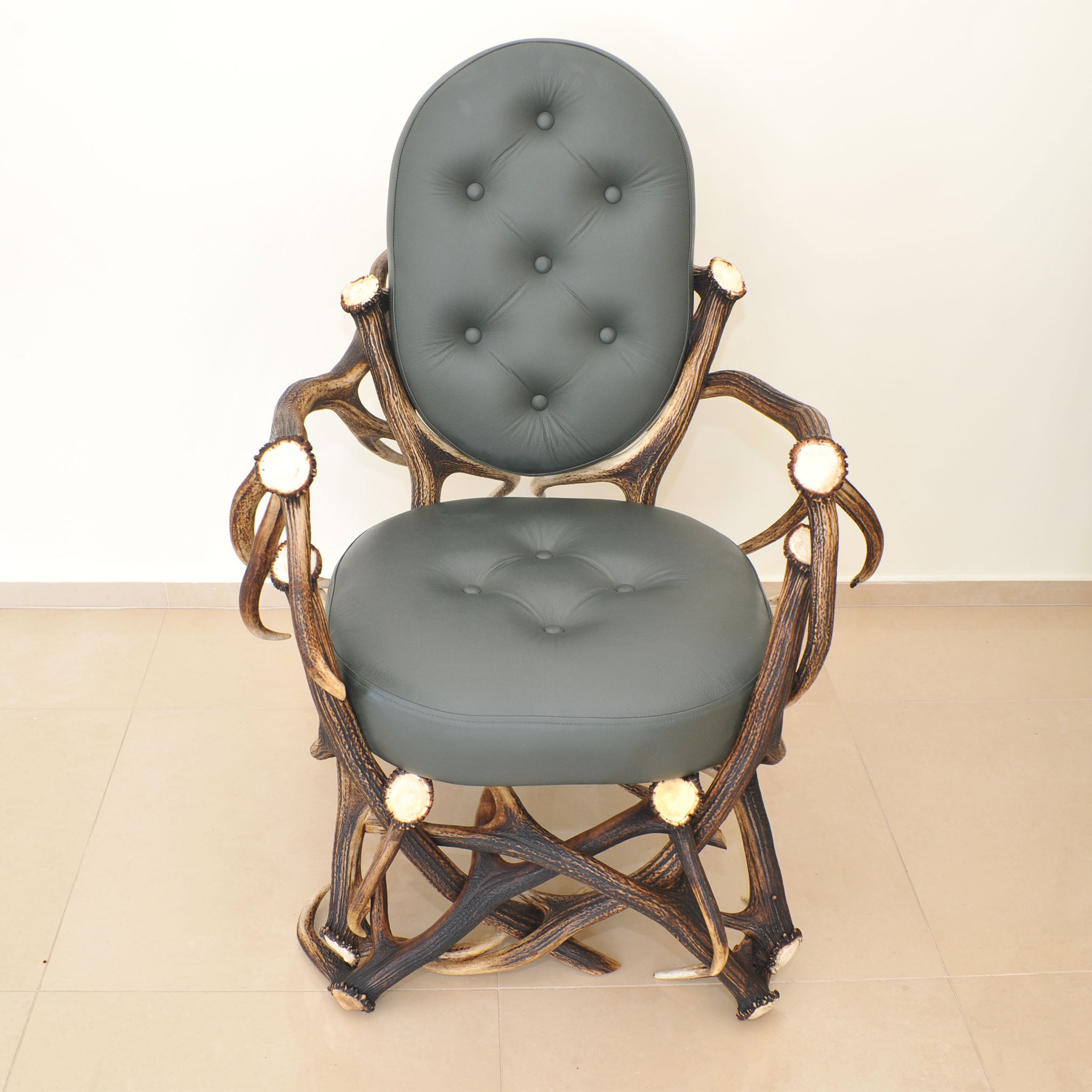 Antler armchair in green colour.