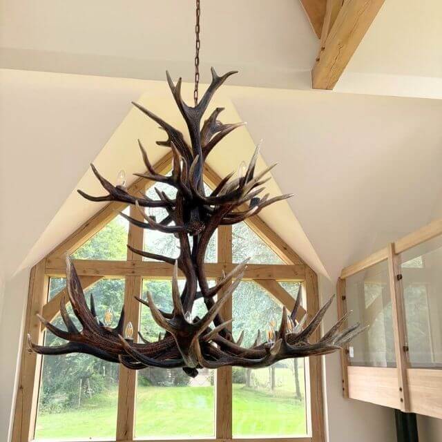 Large deer antler chandelier for 15 lights hanging in modern rustic farmhouse.