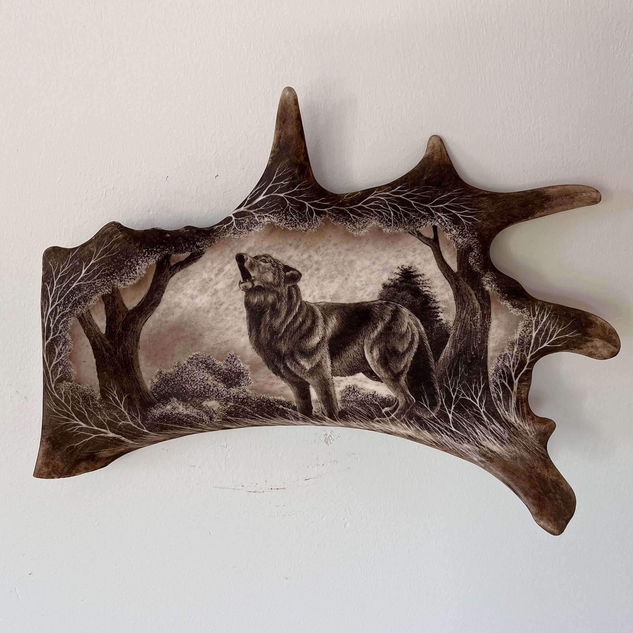 Real antler carving shows wolf.