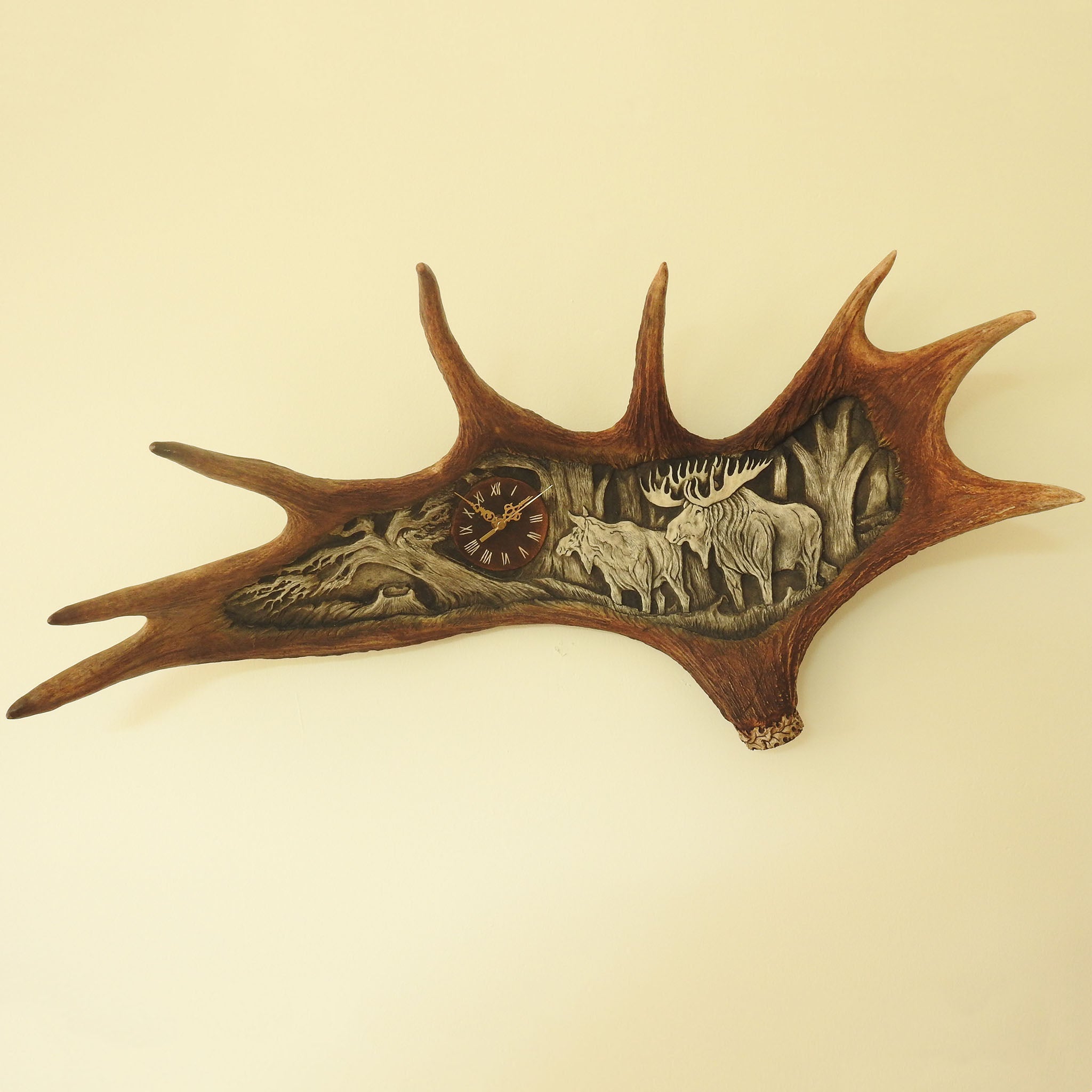 Real moose antler carving shows moose family.