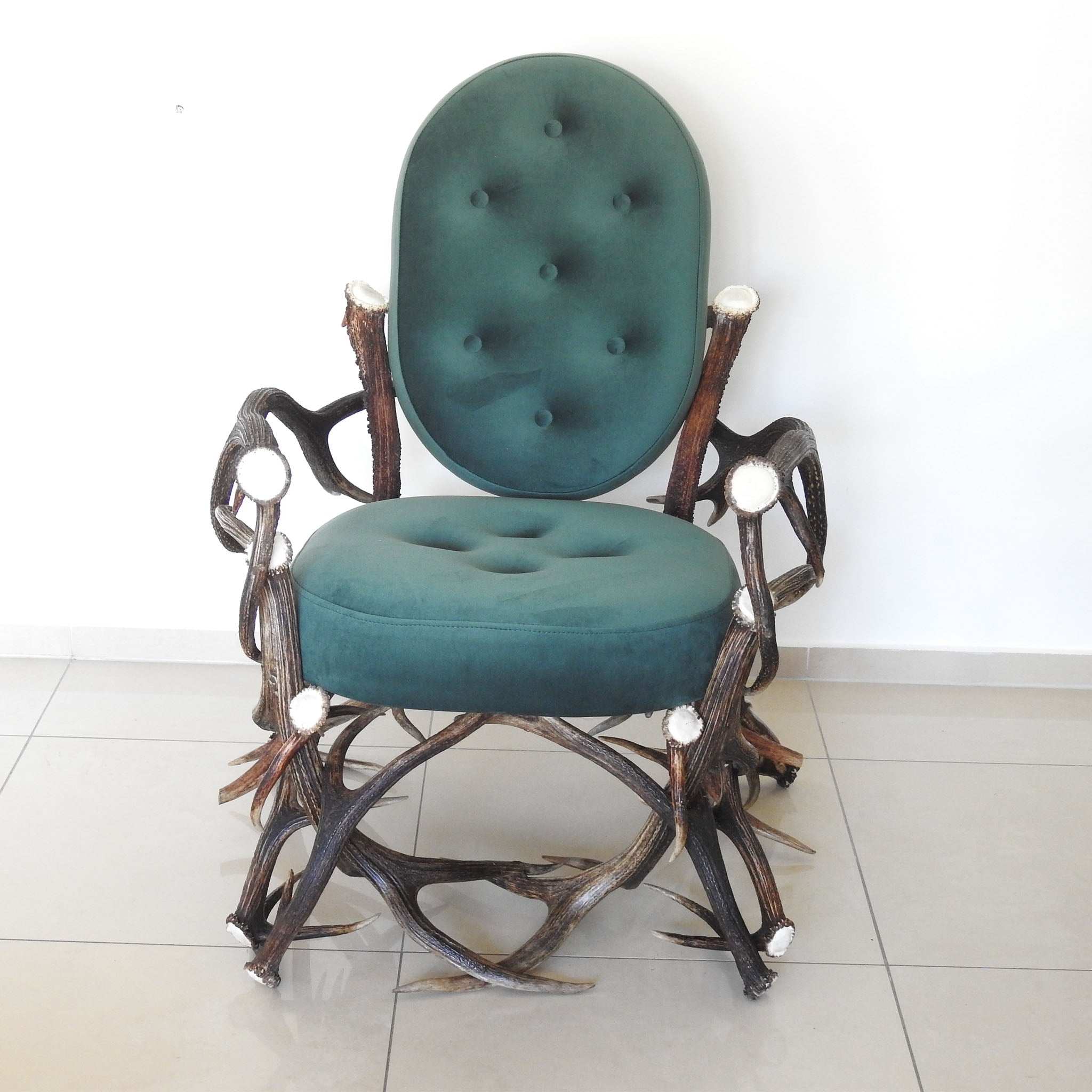 Deer antler chair with velvet upholstery.